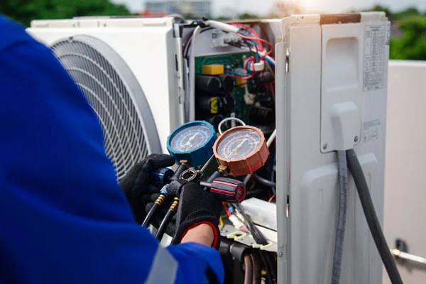 Technician checking an air conditioning unit with pressure gauges
